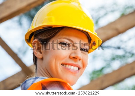 Closeup portrait of smiling female construction worker at site