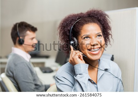Cheerful female customer service representative with male colleague in office