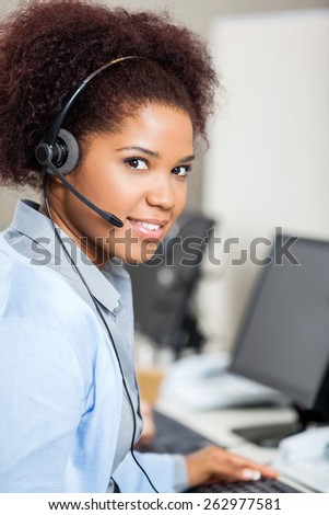 Portrait of young female customer service representative wearing headset in office