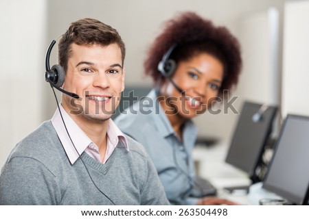 Portrait of smiling colleagues working in call center