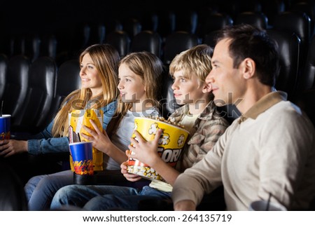 Family having snacks while watching film in movie theater