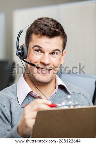 Happy customer service representative with clipboard looking away in office