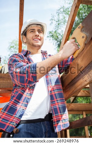 Low angle view of smiling construction worker standing at site