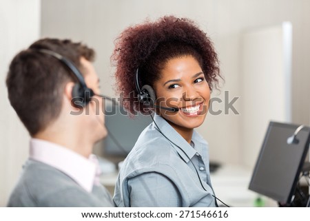 Happy customer service representatives talking with each other in call center