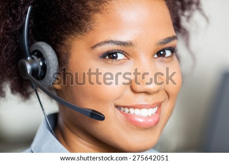 Closeup portrait of smiling female customer service representative wearing headset in office