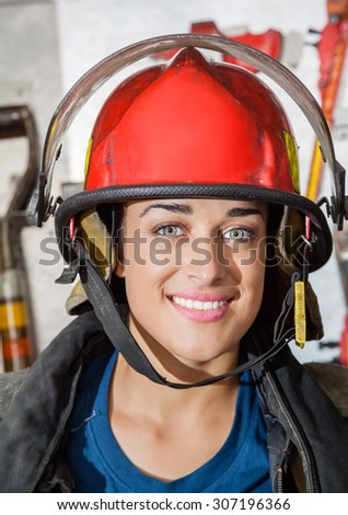 Closeup portrait of happy firewoman at fire station