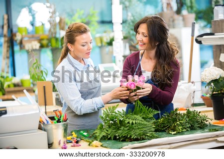 Florists making bouquet of pink roses in flower shop