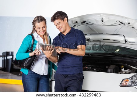 Customer And Mechanic Using Digital Tablet By Car