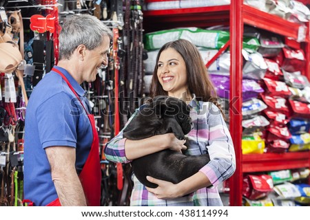 Salesman Looking At Customer With Bulldog In Pet Store