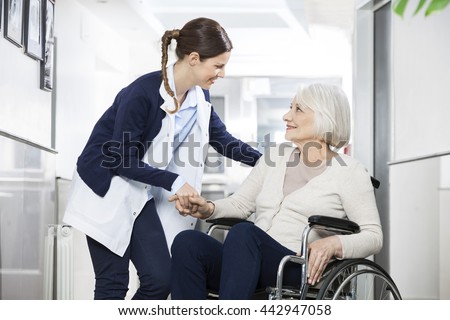 Physiotherapist Consoling Senior Woman Sitting In Wheelchair