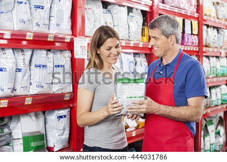 Salesman Assisting Customer In Buying Pet Food At Shop