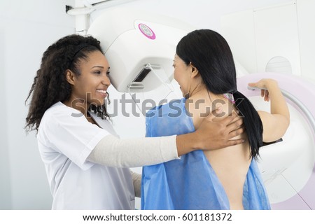 Happy Doctor Assisting Woman Undergoing Mammogram X-ray Test