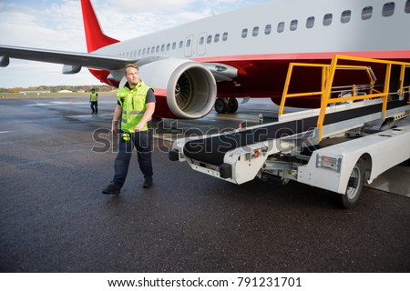 Worker Walking By Conveyor Truck With Airplane On Runway