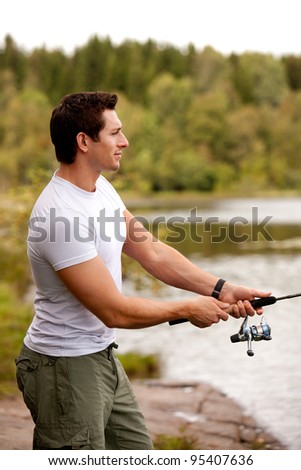 A man fishing on a inerior lake with forest in the background