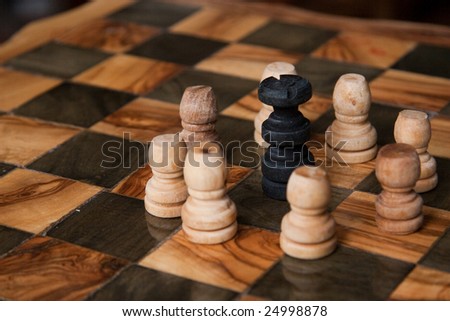 chess game with a black king ringed by some white pawns
