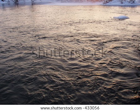 Dark river waters highlighted with a sunset