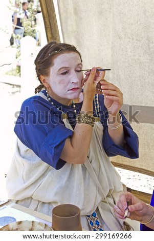 JUNE 6, 2015,  MOSCOW, RUSSIA -  Festival of the historic reconstruction Times and Ages in the park Kolomenskoye. Young woman does an antic make-up