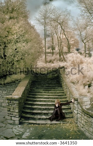 Distressed woman on stone steps in infrared.