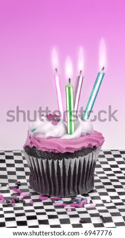 Cupcake with candles with a pink background.