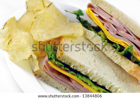 Ham and Cheese Sandwich with potato chips on white background.