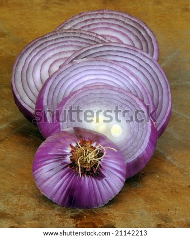 Slices of red onion on a rustic surface.