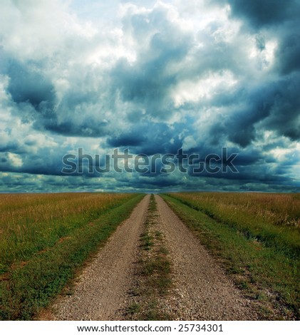 Dirt road through the prairie lands of the American Mid-West with Stormy Clouds.