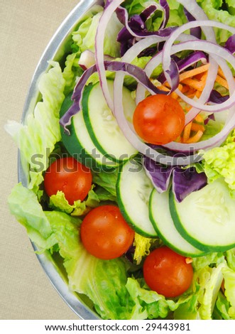 Fresh garden salad with lettuce, tomatoes, cucumbers and onions.