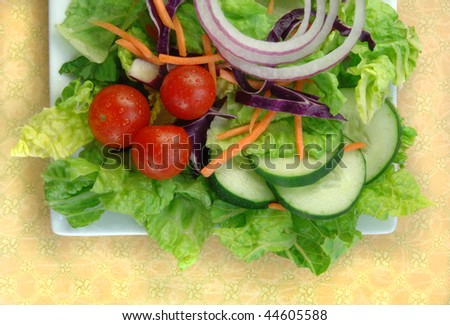 Garden salad on a square white plate.