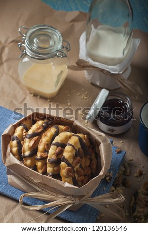 Top view of  package peanut biscuits, jars with jam and condensed milk on brown paper background