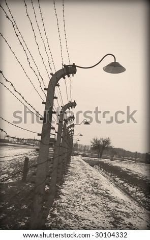 Old style photo of Auschwitz camp, electric fence