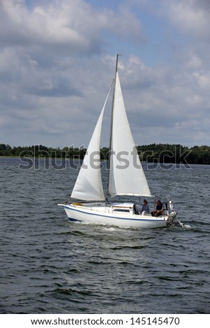 MASURIA, POLAND - JULY 13: Unidentified people sailing on Mazury lake on July 13, 2012 in Masurian ditrict, Poland. More than 5 million tourists visit Masuria every year.