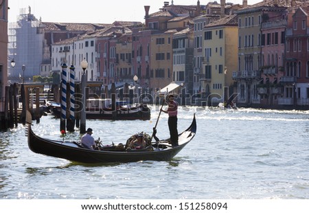 VENICE-AUGUST 18: Gondoliers ride gondolas on the Grand canals in Venice on August 18, 2013. Gondola is one of the symbols of Venice and major mode of touristic transport in Venice, Italy.