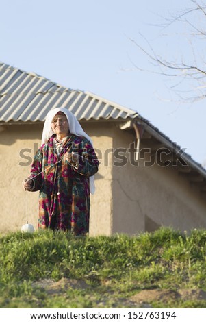 SAMARQUAND, UZBEKISTAN - MARCH 23: Unidentified woman posing for tourist  on March 23, 2012 near Samarquand, Uzbekistan. Uzbekistan is a country with great potential for an expanded tourism industry.