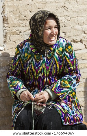 KHIVA, UZBEKISTAN - MARCH 21: Traditionally clothed woman posing for tourist on March 21, 2012 in Khiva, Uzbekistan. Uzbekistan has great potential for an expanded tourism industry.