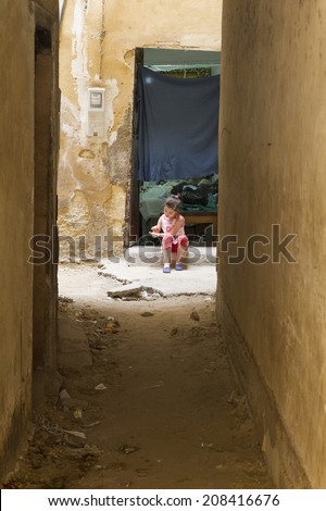 FEZ, MOROCCO - JULY 19: A girl in a souk on July 19, 2014 in Fez, Morocco. The medina is listed as a UNESCO World Heritage Site and is believed to be one of the world\'s largest car-free urban areas.
