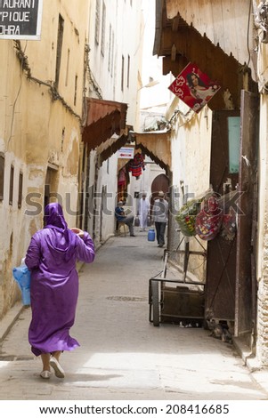 FEZ, MOROCCO - JULY 19: Woman in a souk on July 19, 2014 in Fez, Morocco. The medina is listed as a UNESCO World Heritage Site and is believed to be one of the world\'s largest car-free urban areas.