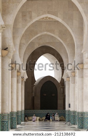 CASABLANCA, MOROCCO - JULY 23: Local people sitting at a door of King Hassan II Mosque on July 23, 2014 in Casablanca, Morocco. It is the largest Mosque in the country
