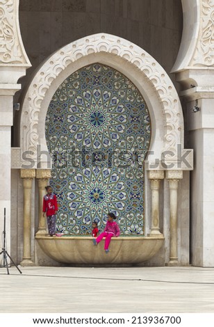 CASABLANCA, MOROCCO - JULY 23: Local people sitting at a fountain of King Hassan II Mosque on July 23, 2014 in Casablanca, Morocco. It is the largest Mosque in the country