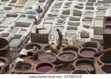 FEZ, MOROCCO - JULY 19: Workers in the tannery souk of weavers on July 19, 2014 in Fez, Morocco. The tannery souk of weavers is the most visited part of the 2000 years old city.