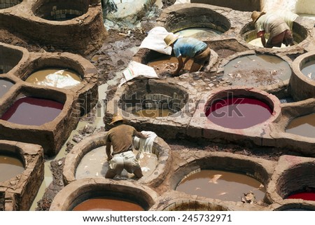 FEZ, MOROCCO - JULY 19: Workers in the tannery souk of weavers on July 19, 2014 in Fez, Morocco. The tannery souk of weavers is the most visited part of the 2000 years old city.