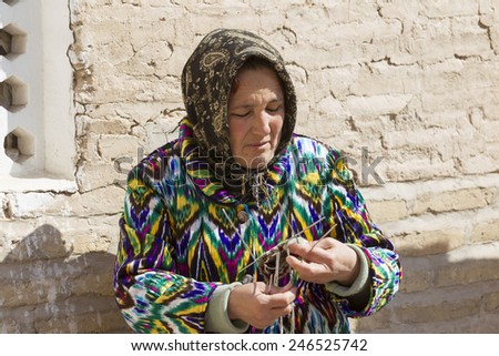 KHIVA, UZBEKISTAN - MARCH 21: Traditionally clouded woman posing for tourist  on March 21, 2012 in Khiva, Uzbekistan. Uzbekistan has great potential for an expanded tourism industry.