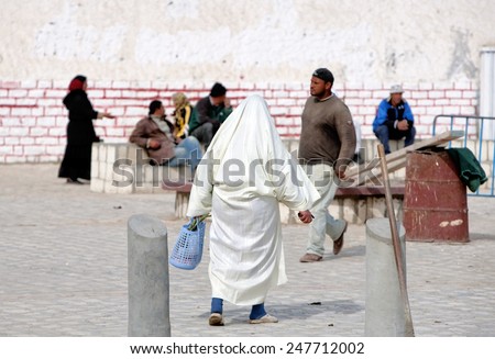 BIZERTE, TUNISIA - FEBRUARY 6: Traditional clothed woman in the medina of the city on February 6, 2009 in Bizerte, Tunisia. Bizerte is known as the oldest and most European city in Tunisia.
