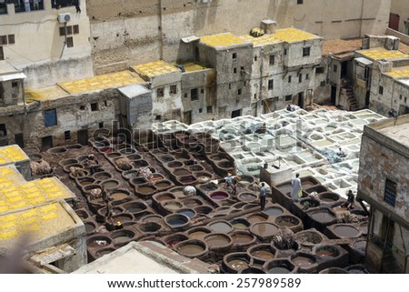 FEZ, MOROCCO - JULY 19: Workers  in the tannery souk of weavers on July 19, 2014 in Fez, Morocco. The tannery souk of weavers is the most visited part of the 2000 years old city.