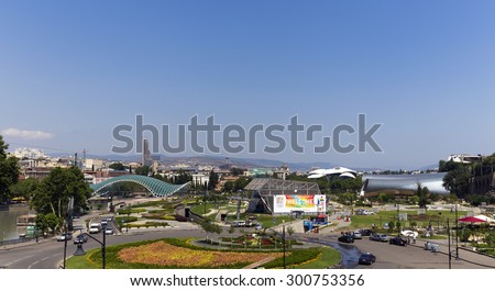 TBILISI, GEORGIA - JULY 18, 2015: The new, not yet finished theatre building  (r) and the cabel car station on the left bank of the Kura River, in the Avlabari district.