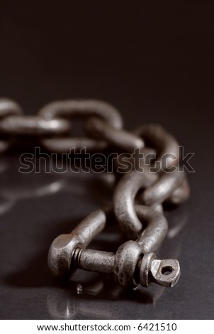 Old weathered industrial chain with ring clamp.