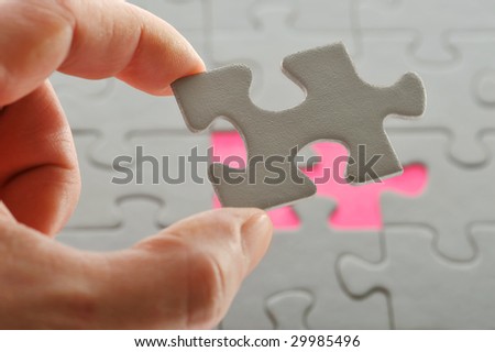 Puzzle and Hand. The last piece of a puzzle game