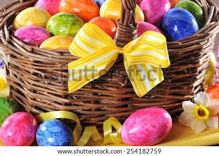 easter basket with many colored easter eggs and yellow bow