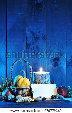small pumpkin in basket on old weathered wooden floor in blue sunset light