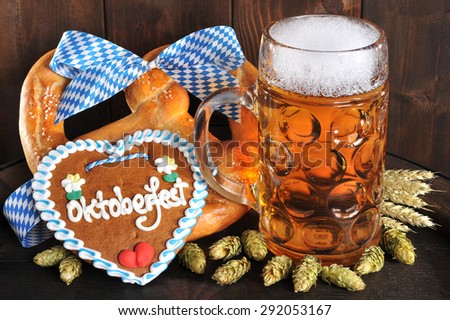original bavarian Oktoberfest big soft pretzel with beer mug, hops and gingerbread heart from Germany on old beer barrel
