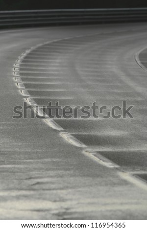 Wet bend in a road with a broken white line after the rain